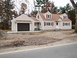 cape style house with attached garage and porch